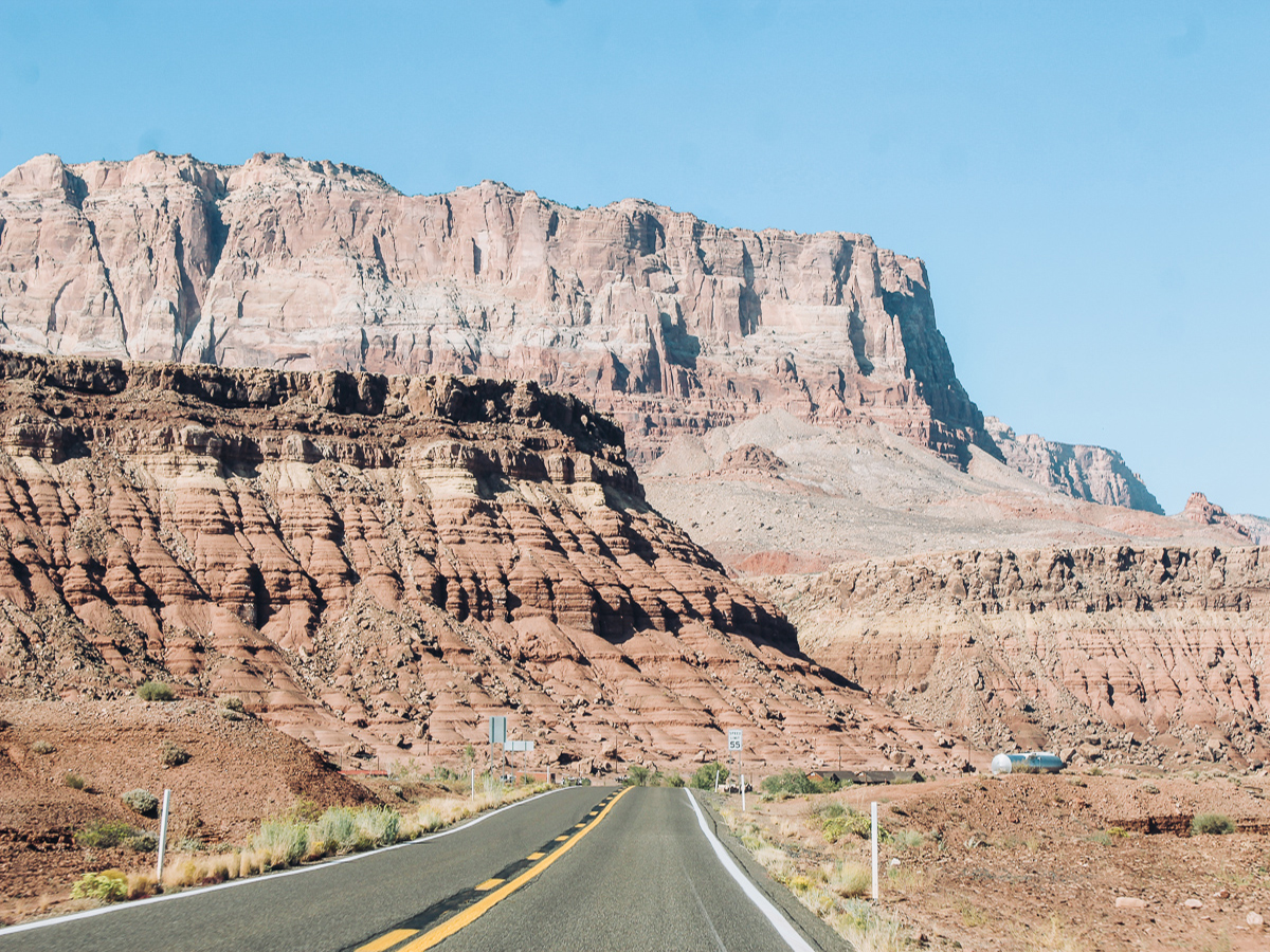 Highway passing in front of the pink colored Vermilion Cliffs