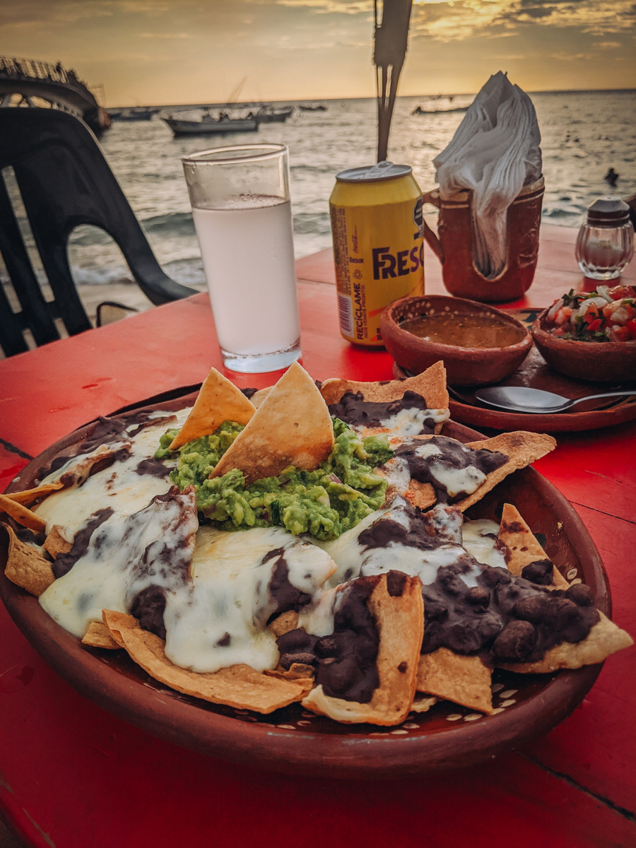 a plate of nachos on the table overlooking the ocean in Puerto Vallarta, Mexico