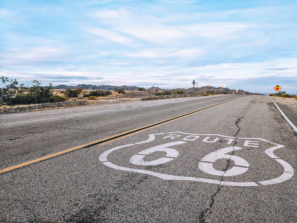 a painting that says Route 66 on the pavement of a road on how to plan a road trip
