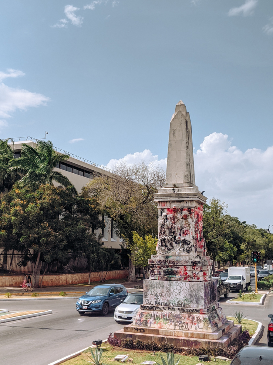 a statue covered in graffiti after a protest in Merida