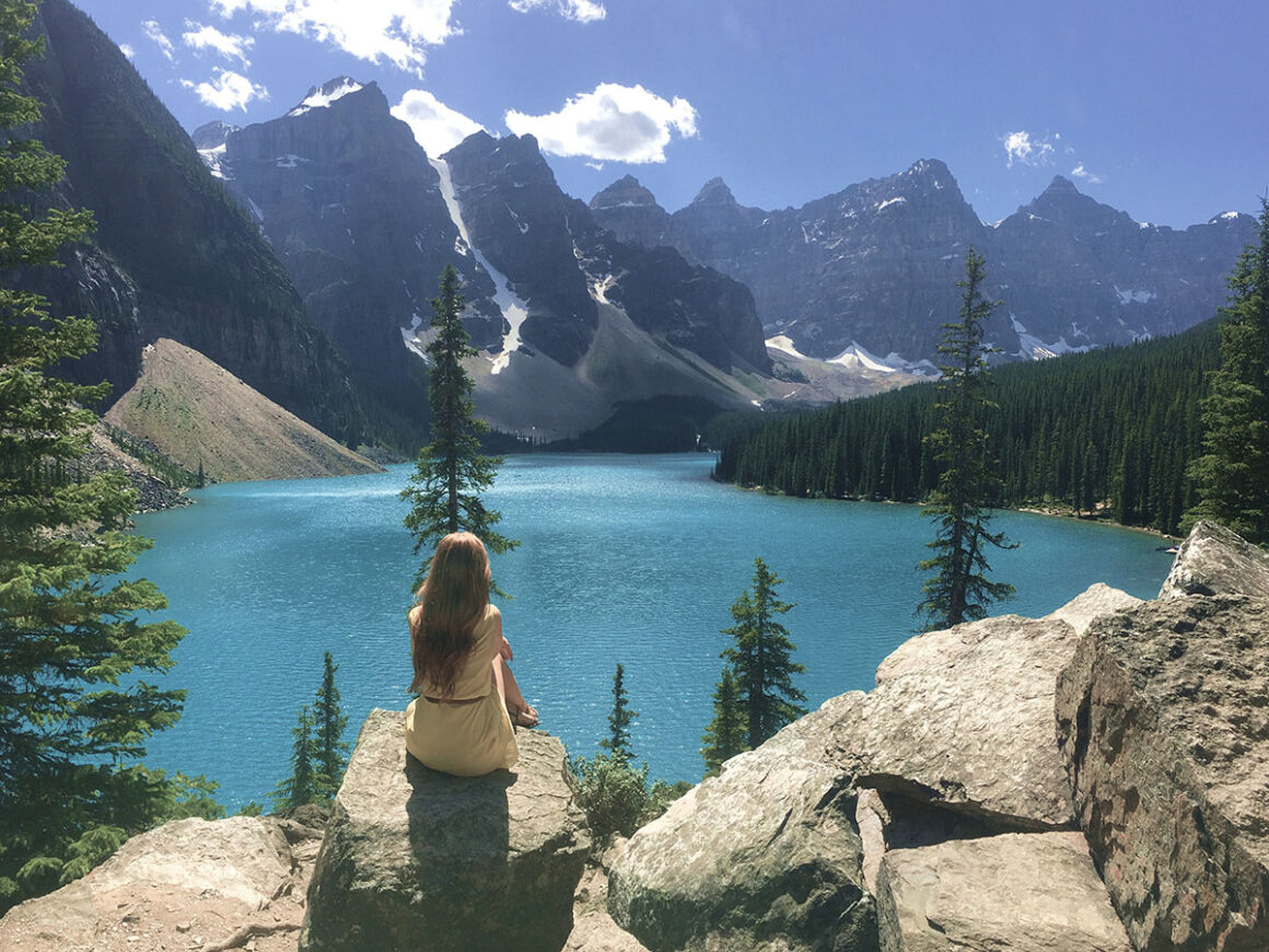 an overlook with a girl looking at Moraine Lake