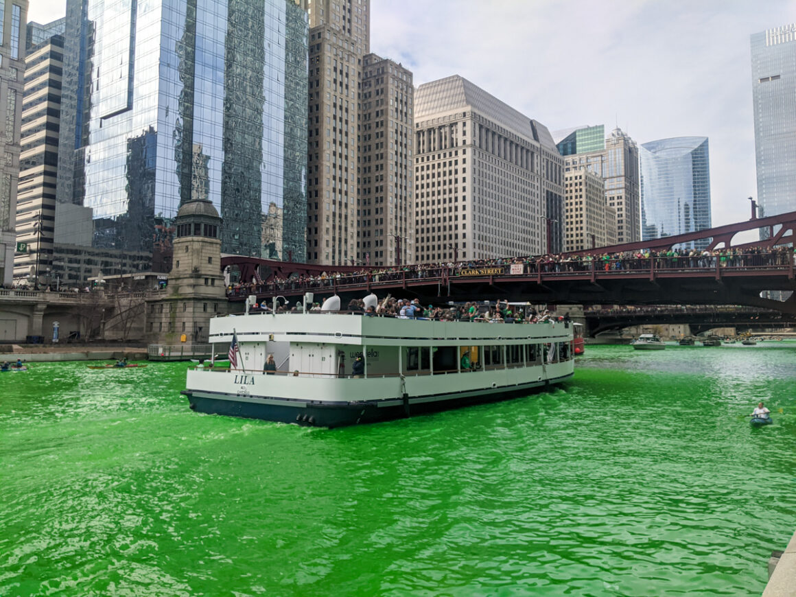 A white boat on the Chicago River in spring when they dye the river green