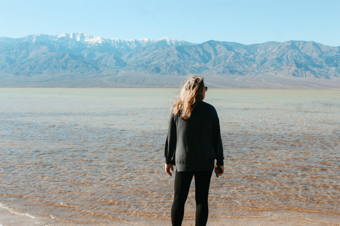 a girl standing in front of Lake Manly, Death Valley National Park