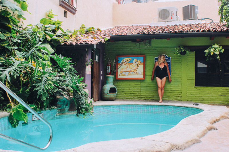 a blue pool in Puerto Vallarta with a girl standing next to it