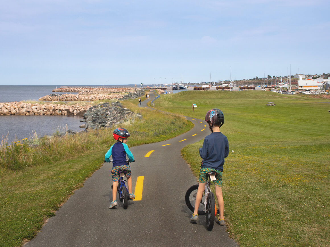 two children riding bikes along the shores of the Acadian Peninsula