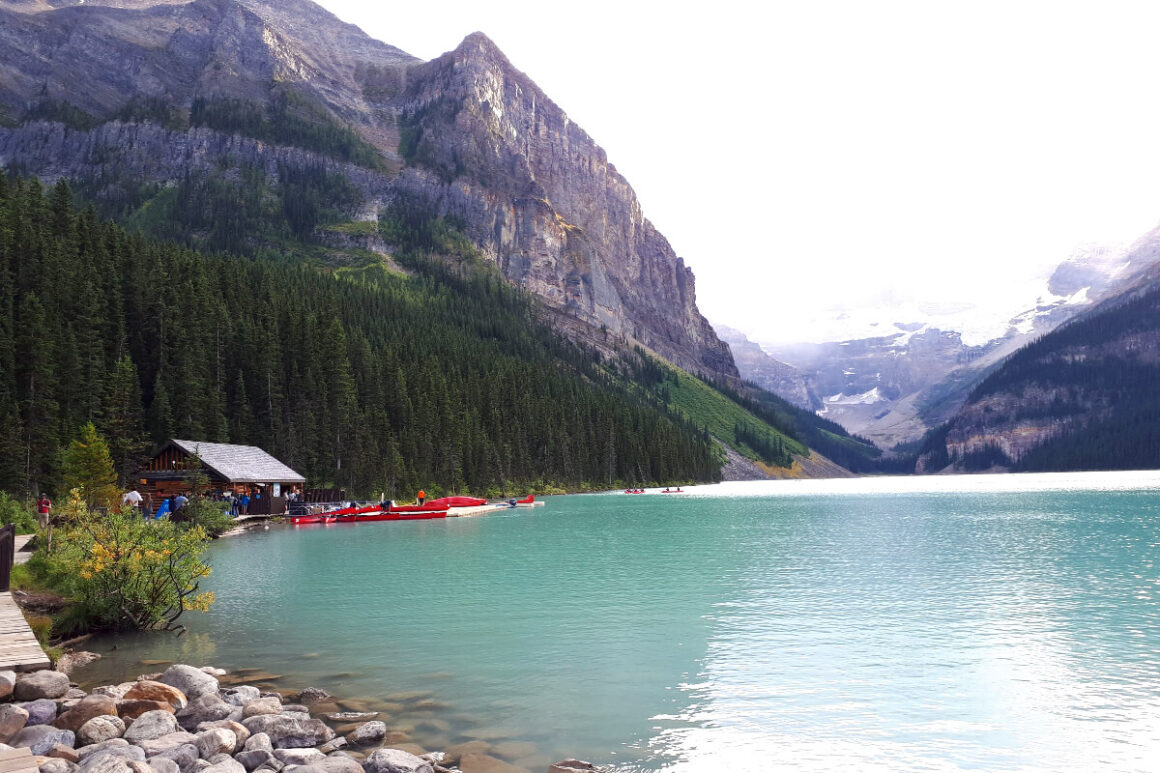 A bright blue green lake with canoes near Banff, Alberta