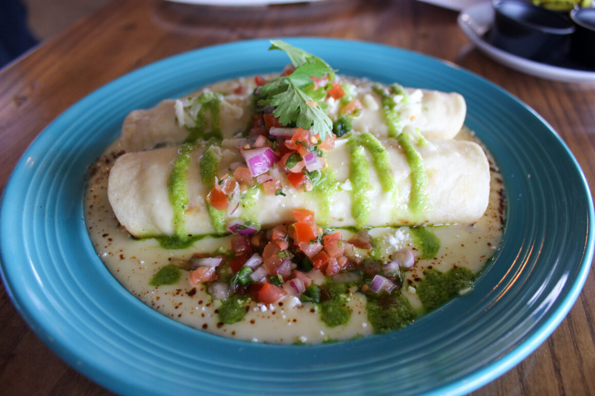 enchiladas covered with guacamole at Bow & Arrow Auburn, Alabama