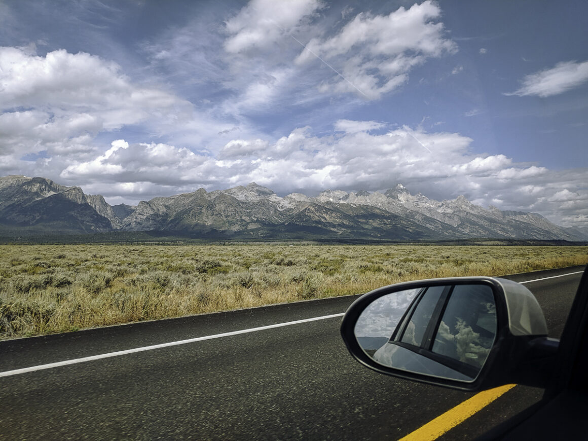 scenic drive through Grand Teton National Park with Teton mountain range in the background