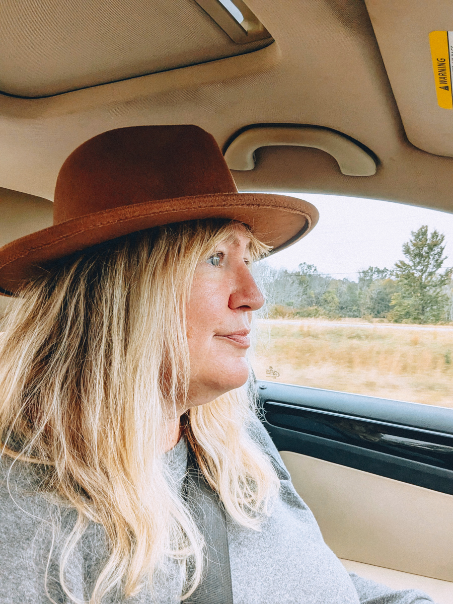 a girl in a hat driving a car