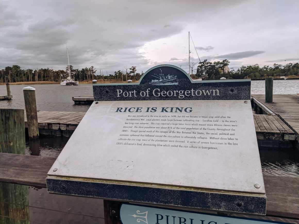 a sign for the port of Georgetown with boats in the background